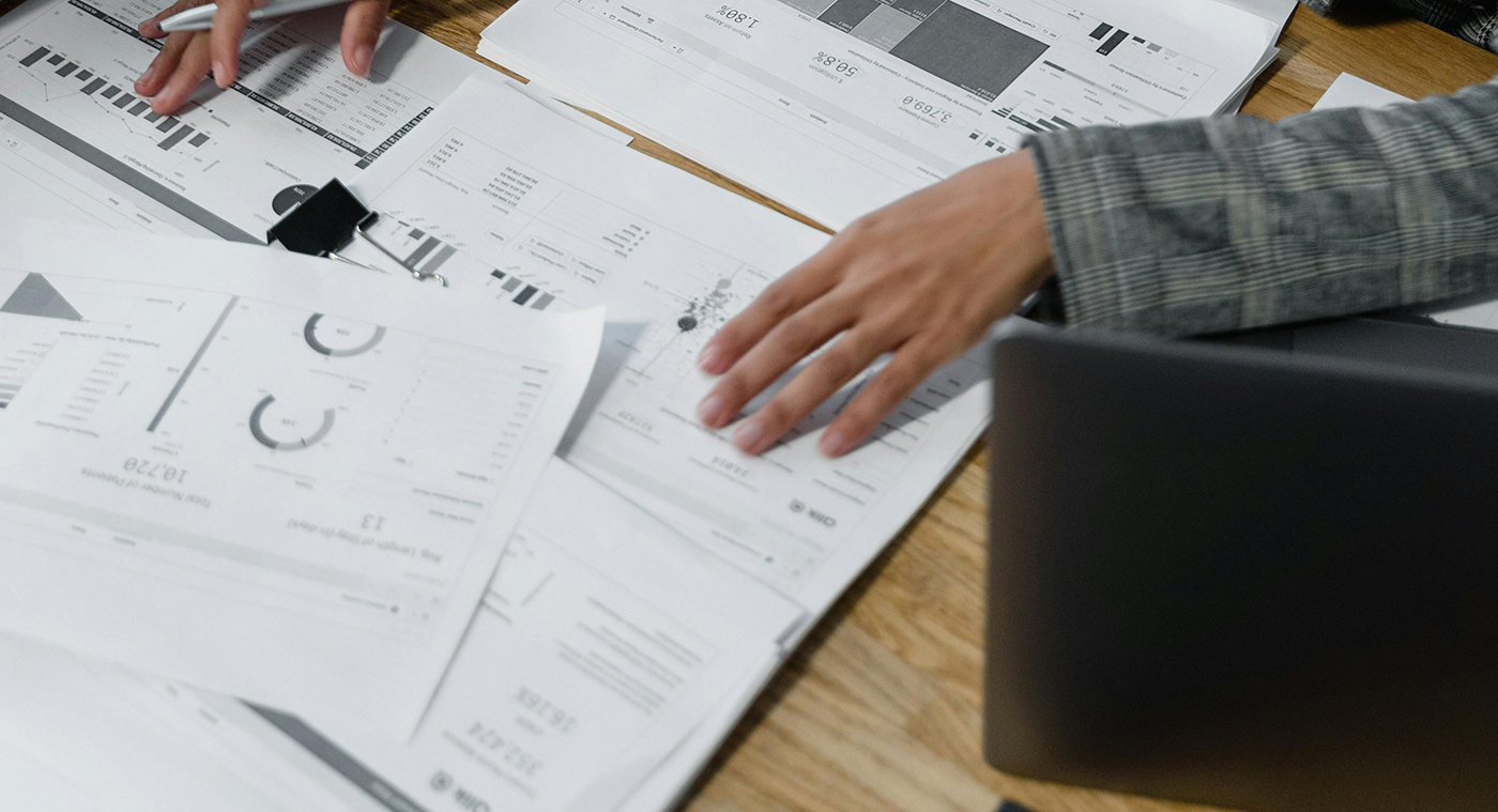 Mains analysant des tableaux de bord financiers et graphiques sur un bureau : pilotage de la trésorerie d'une PME selon la méthode des 4 comptes.